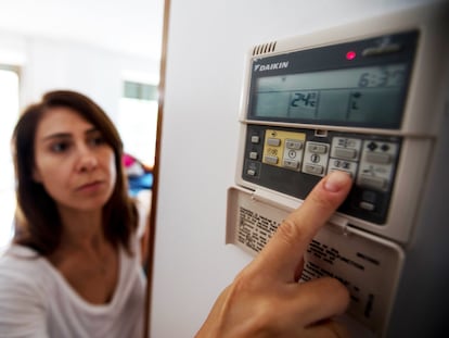 Una mujer pone el aire acondicionado en su vivienda, en Madrid.