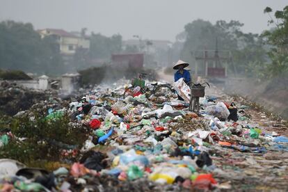 Una mujer recorre un montón de basura al lado de una carretera en Bac Ninh, al este de Hanoi (Vietnam).