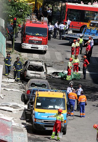 Bomberos, policías y operarios, en la calle del atentado.