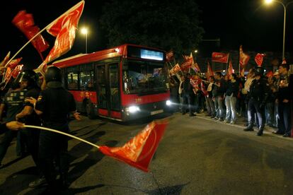 Un conductor sale de las cocheras ayudado por los agentes y ante los gritos de los sindicalistas.