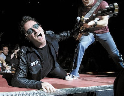 Bono, líder de U2, cantando 'End of the World' durante un concierto en 2001 con Edge a su izquierda.