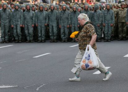 Una mujer cruza una calle frente a un cordón de militares, el lunes en el centro de Kiev.