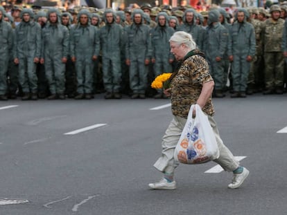 Una mujer cruza una calle frente a un cordón de militares, el lunes en el centro de Kiev.