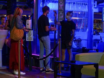 Un empleado toma la temperatura a un joven que hace cola para entrar en un pub en el puerto deportivo de Marbella, en una foto de archivo.
