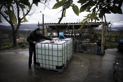 Un vecino revisa los dos depósitos de 1.000 litros instalados por el Ayuntamiento en cada vivienda de O Contrasto para el aseo, la limpieza doméstica y abrevar los animales. Los bomberos pasan varias veces a la semana para rellenarlos.