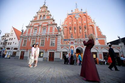 Dos turistas se hacen una foto ante la casa de los cabezas negras, en Riga (Letonia).