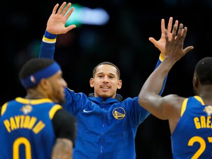 Juan Toscano, alero de los Golden State Warriors, saluda a Gary Payton II y Draymond Green durante el juego en que se coronaron campeones de la NBA, el 16 de junio de 2022.