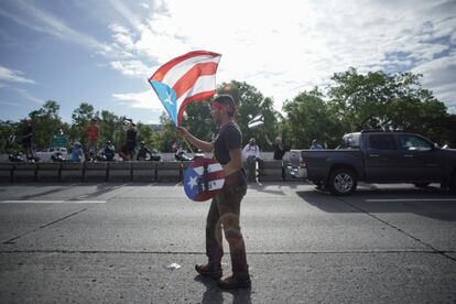 Un manifestante ondea la bandera puertorriqueña en San Juan (Puerto Rico), este lunes, en el noveno día de protestas consecutivas en las que se exige la renuncia del gobernador Ricardo Rosselló. Las protestas estallaron la semana pasada luego de la filtración de cientos de páginas de chats en las que se hace referencias homofóbicas a la superestrella latina Ricky Martin, comentarios burlones sobre los cuerpos apilados en la morgue después del huracán María, entre otros.