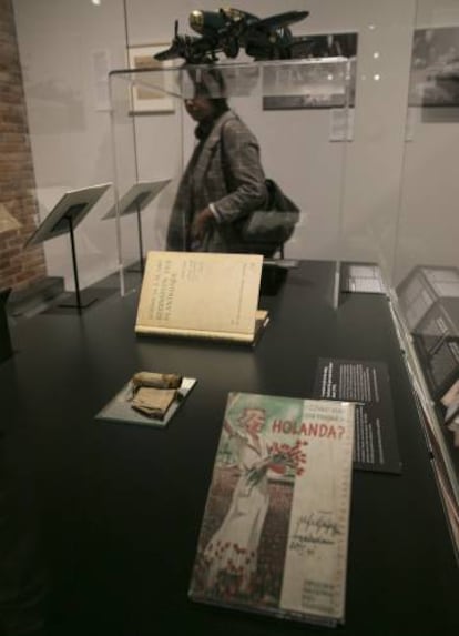 Guía turística de Holanda (en primer plano), tirador de madera (izquierda) y tratado de botánica de Ana Frank, objetos incorporados a la exposición 'Auschwitz'.