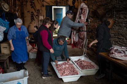 Vecinos del pueblo hacen la tradicional matanza del cerdo en un garaje.