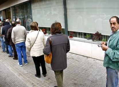 Varias personas forman una cola a la entrada de la oficina del Servicio Valenciano de Empleo, en Valencia, el mes pasado.