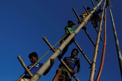 Varios refugiados rohingya suben a un andamio de bambú mientras perforan un pozo de agua en el campamento de refugiados de Mayner Ghona, cerca de Cox's Bazar (Bangladés).