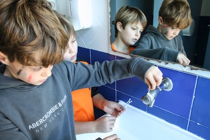 Alumnos de la escuela Joan Torredemer Canela de Matadepera (Barcelona) colocan bridas en los grifos del centro.