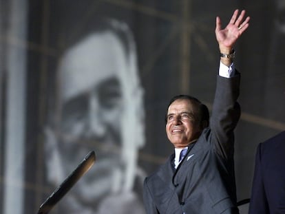 Carlos Menem saluda a sus simpatizantes, con un retrato del extinto presidente argentino Juan Domingo Perón como telón de fondo, en el estadio de River Plate, en abril de 2003.