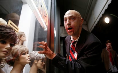 Un hombre de negocios zombi mira los maniquíes de una tienda de pelucas durante la caminata zombie de Silver Spring, Maryland (EE.UU). 