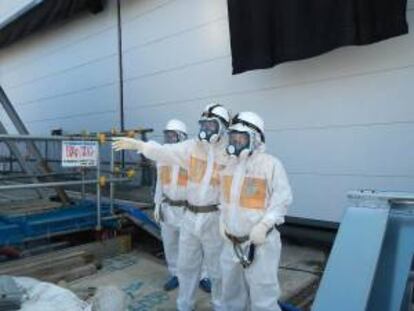 En la imagen, facilitada por TEPCO el profesor del Instituto de Tecnología de Tokio Katsuki Takiguchi (dcha) mientras visita el edificio del reactor nº 4 en la central nuclear de Fukushima Daiichi, en Okuma (Japón). EFE/Archivo
