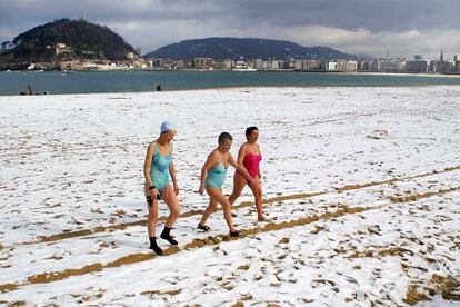 Varias personas desafiaron ayer al frío y la nieve en la playa de San Sebastián.