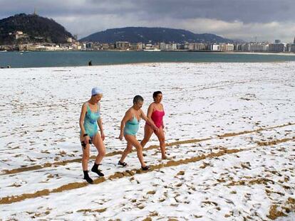 Varias personas desafiaron ayer al frío y la nieve en la playa de San Sebastián.