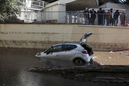 La gente observa un coche abandonado en Cannes