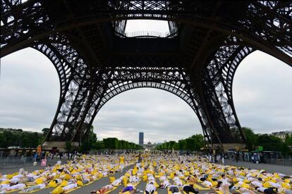 Centenars de persones fan ioga a París, diumenge.