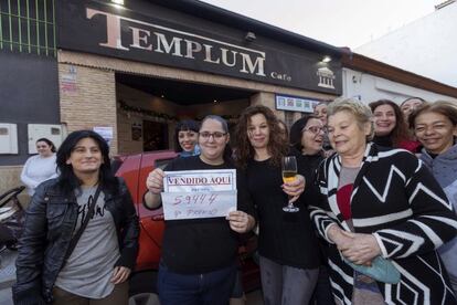 La vendedora de un cuarto premio de la loteria de navidad, el número 59.444, Cristina Canovas (2i), junto a su suegra, dueña del café el Templo, Josefina Moreno (c), celebran la venta del número acompañados de vecinos, hoy en Rincón de Seca, Murcia. 