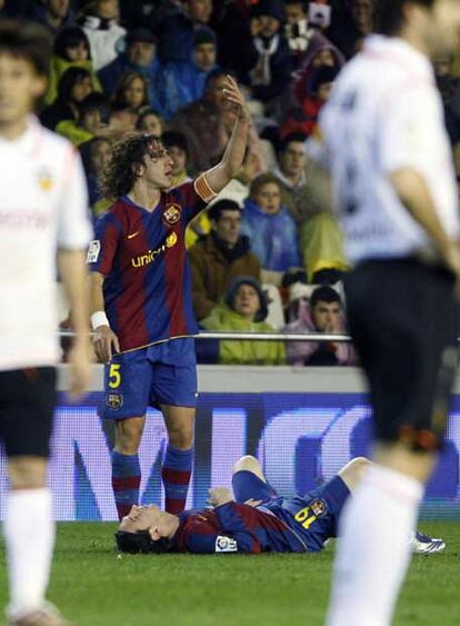 Puyol pide la asistencia del masajista para Messi, que se duele sobre el césped.