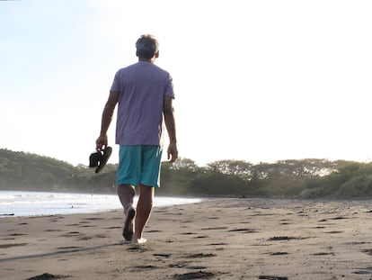 Un hombre pasea por la playa.
