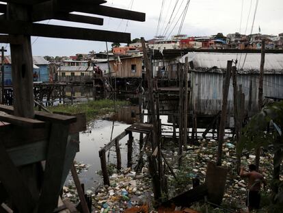 Moradores caminham entre o lixo na região de Educandos, em Manaus, no último 19 de maio.