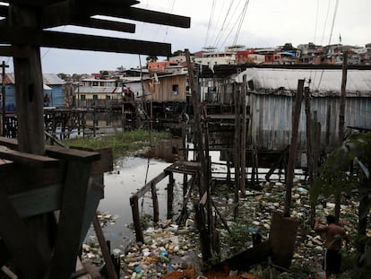 Moradores caminham entre o lixo na região de Educandos, em Manaus, no último 19 de maio.