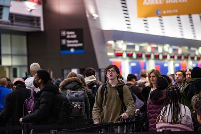 Travelers wait at Logan International Airport in Boston on Friday as the US faced holiday travel chaos.