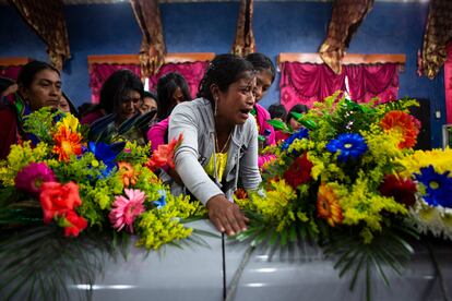 Una familiar de Pascual Melvin Guachiac Sipac, de 13 año, abraza su ataúd durante el funeral, en Tzucubal, Nahuala, Guatemala, el sábado 16 de junio de 2022.