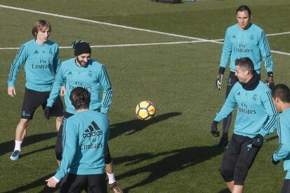 Benzema, con gorro, bromea con Cristiano en un rondo en el entrenamiento de este viernes. 