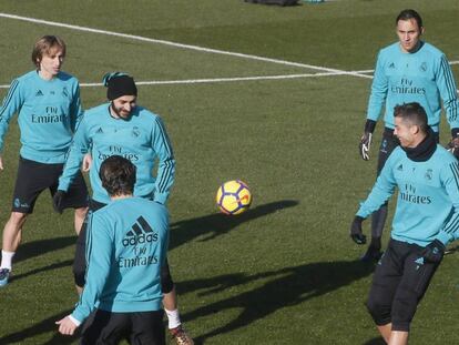 Benzema, con gorro, bromea con Cristiano en un rondo en el entrenamiento de este viernes. 