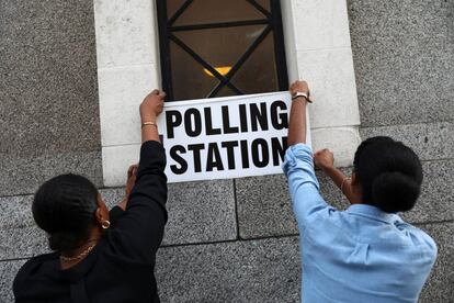 Trabajadores preparan carteles electorales en el exterior de un centro electoral en Londres.