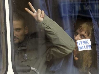 Un joven activista muestra un cartel que dice "Georgia, estamos contigo" en un furgón policial tras su detención ayer ante la Embajada de Georgia en Moscú.