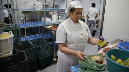 Una empleada prepara las bolsas con el desayuno y la merienda.