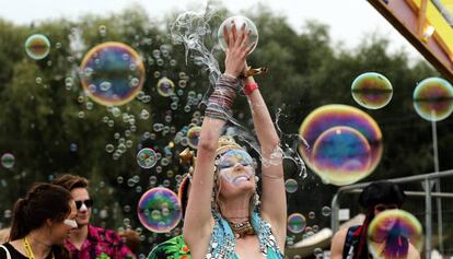 Una asistente al Bestival de Inglaterra, rodeada de burbujas de jabón.