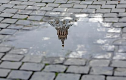 Vista de la cúpula de la basílica de San Pedro reflejada en un charco tras el anuncio de renuncia hecho por el papa Benedicto XVI.