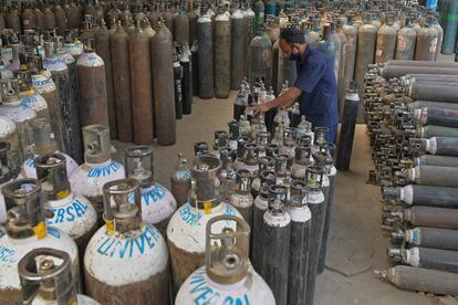 Un trabajador clasifica las botellas de oxígeno que se utilizan para los pacientes del coronavirus en una instalación en Bangalore (India), antes de enviarlas a los hospitales.