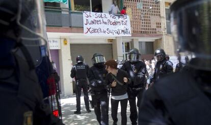 Mossos d&rsquo;Esquadra detienen a una de las personas que intentaban evitar el desahucio de una familia en el barrio del Clot, en Barcelona.