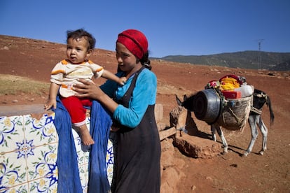 Mina, de 13 años, con su bebé en uno de las pocas fuentes que hay en la zona. Las mujeres son las encargadas de ir a buscar  el agua, y muchas veces tienen que recorrer muchos kilómetros para llegar al manantial.

