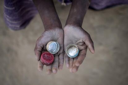 El niño Abdul Hafez, de 5 años, que llegó a Bangladés en septiembre, sostiene unas tapas de botellas que usa para jugar a un juego llamado 'Medakhela' en el campamento de refugiados en Cox's Bazar.