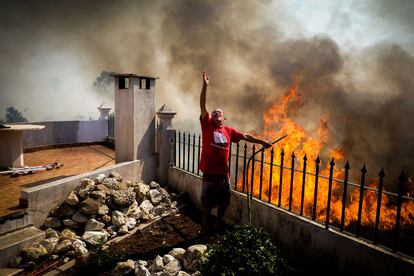 Portugal sufre desde hace cuatro días una oleada de incendios, que ya ha afectado a 2.500 hectáreas y que podría agravarse con las condiciones meteorológicas que se prevén para los próximos días, con vientos intensos, noches tropicales y temperaturas que superarán los 40 grados en numerosas zonas, que además se suman a la situación de sequía que atraviesa el país.  En la imagen, un vecino de Caneças, a las afueras de Lisboa, intenta sofocar con una manguera las llamas que amenazan una vivienda, el domingo 10 de julio.
