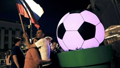 Dos aficionados al fútbol en Moscú, donde se está celebrando el Mundial de fútbol, celebran la victoria de su país.