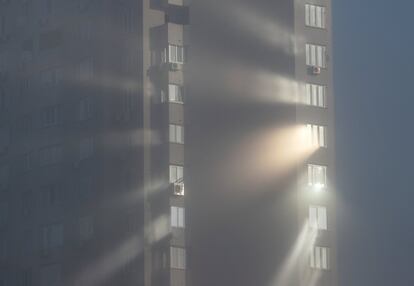 La luz del sol se refleja desde las ventanas de un edificio de apartamentos en un brumoso día de otoño en Kiev (Ucrania).