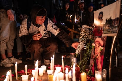 Un jóven coloca flores en un altar para los líderes sociales Camilo Sánchez y Camila Ospitia, líderes sociales asesinados en el barrio El Porvenir, en Bosa, en agosto de 2024.