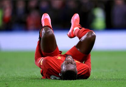 Origi, tendido sobre el césped, se duele durante el partido contra el Chelsea en Stamford Bridge.