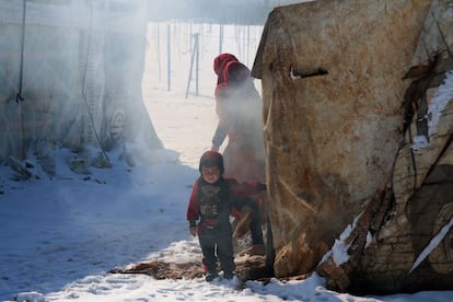 Una mujer siria y un niño en la nieve en el campo de refugiados sirios de al-Hilal en el pueblo de al-Taybeh (Líbano).