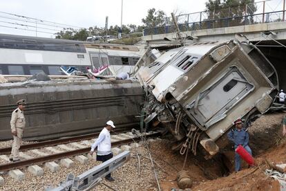 Un oficial de policía y trabajadores del tren junto al lugar del suceso.