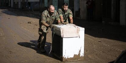 Dos militares ayudan en las tareas de limpieza.